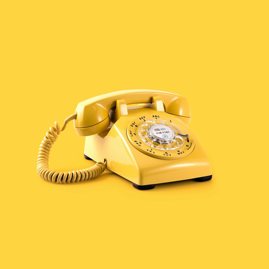 Gul telefon med skive på gul bakgrunn